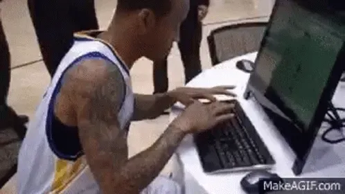 A man hammering away at a keyboard with two fingers, typing frantically.